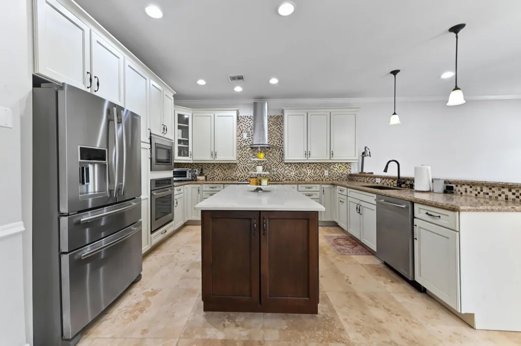 20260922220138865240000000-o - Lake Worth Homes - Lake Worth Homes Modern kitchen with white cabinets, stainless steel fridge and appliances, and a dark wood island at center.