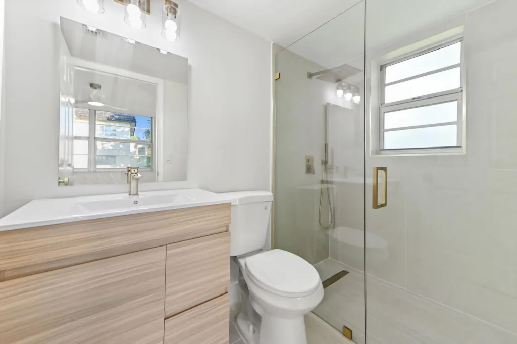 20260929180627405900000000-o - Lake Worth Homes - Lake Worth Homes Modern bathroom with a light wood vanity, white countertop and sink, and a large mirror above.