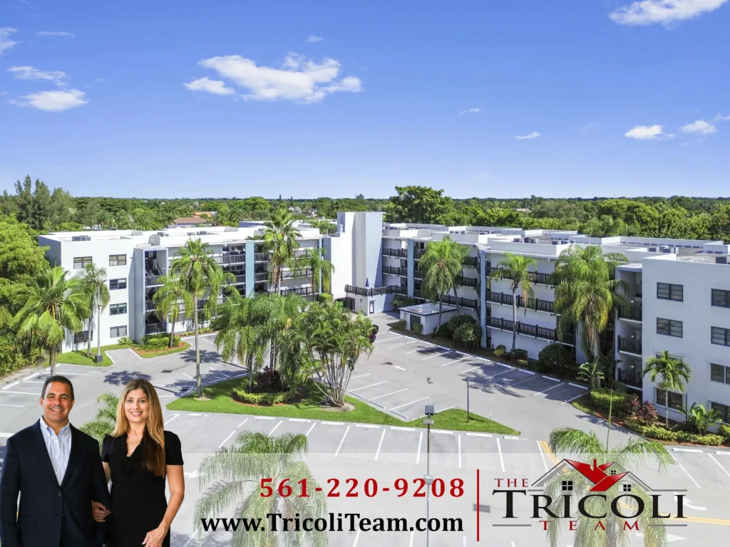 DCIM100MEDIADJI_0267JPG - Lake Worth Homes - Lake Worth Homes Advertisement banner for the Tricoli Team real estate, featuring two agents in front of white apartment buildings with palm trees and a blue sky in the background.