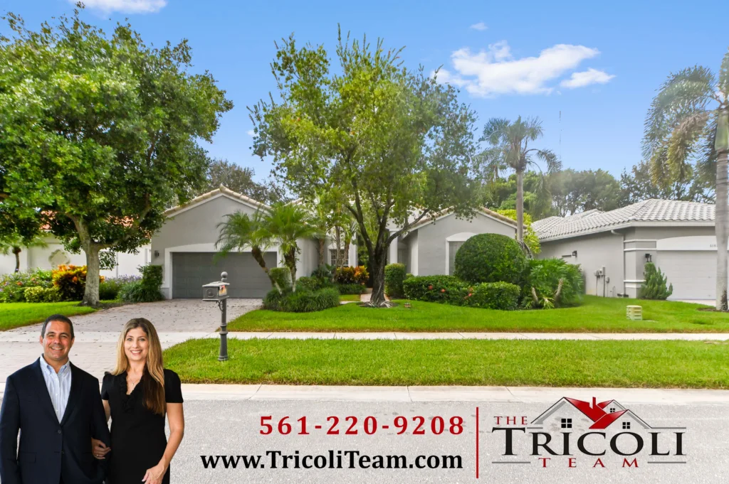 Homes for Sale in Towne Park Lake Worth FL 33467 13 - Lake Worth Homes - Lake Worth Homes Sunny suburban street with two real estate agents in foreground and a sign advertising The Tricoli Team, phone number 561-220-9208, on a clear day.