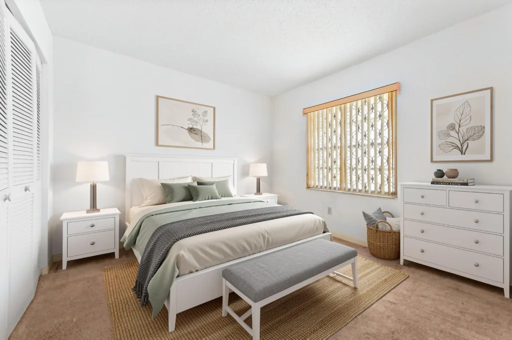 20261008162211336421000000-o - Lake Worth Homes - Lake Worth Homes White, minimalist bedroom with a white bed, matching nightstands, and a dresser; sage bedding and a woven rug under a bench at the foot of the bed.