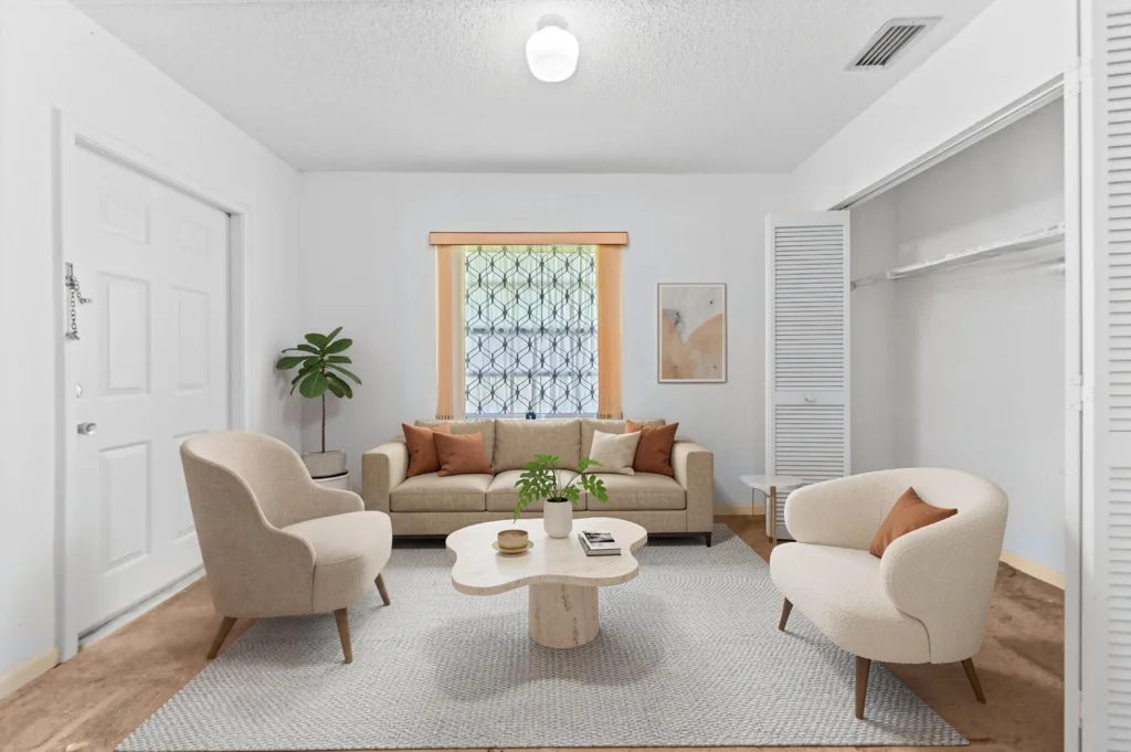 20261008162159542911000000-o - Lake Worth Homes - Lake Worth Homes Neutral living room with beige sofa, two cream chairs, a curved coffee table, and a potted plant; lattice window behind.