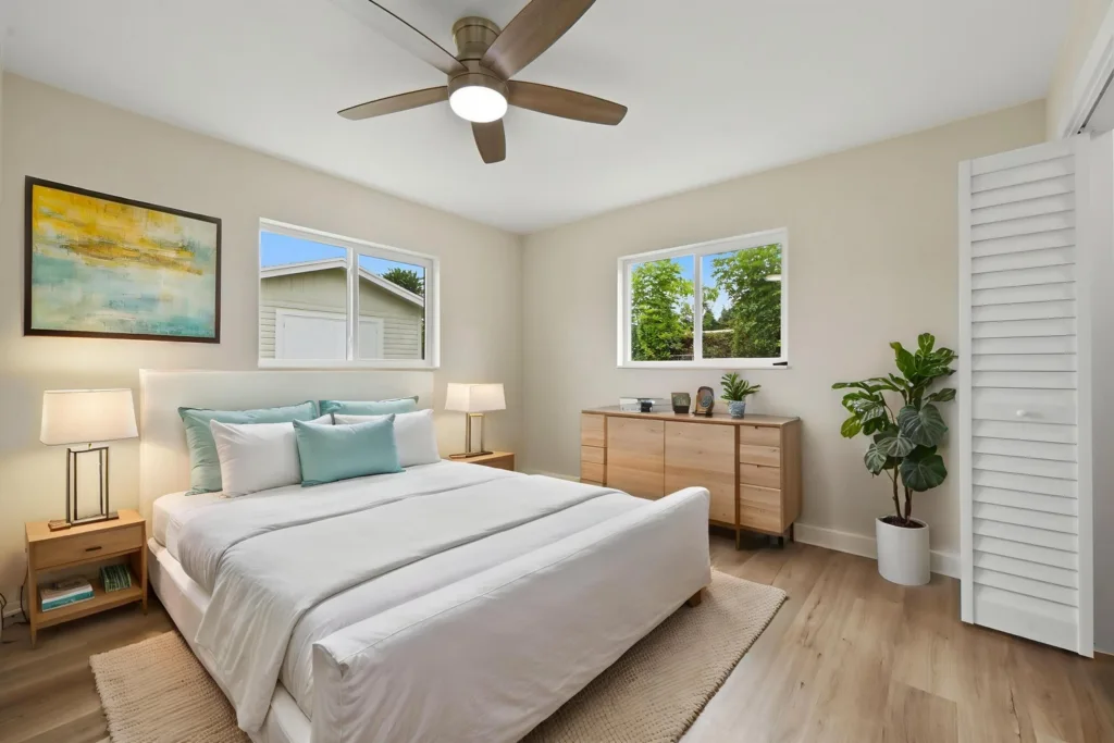 20261021192339800135000000-o - Lake Worth Homes - Lake Worth Homes Bright modern bedroom with white bedding, teal accents, and wood furniture including a dresser and nightstands, plus a ceiling fan